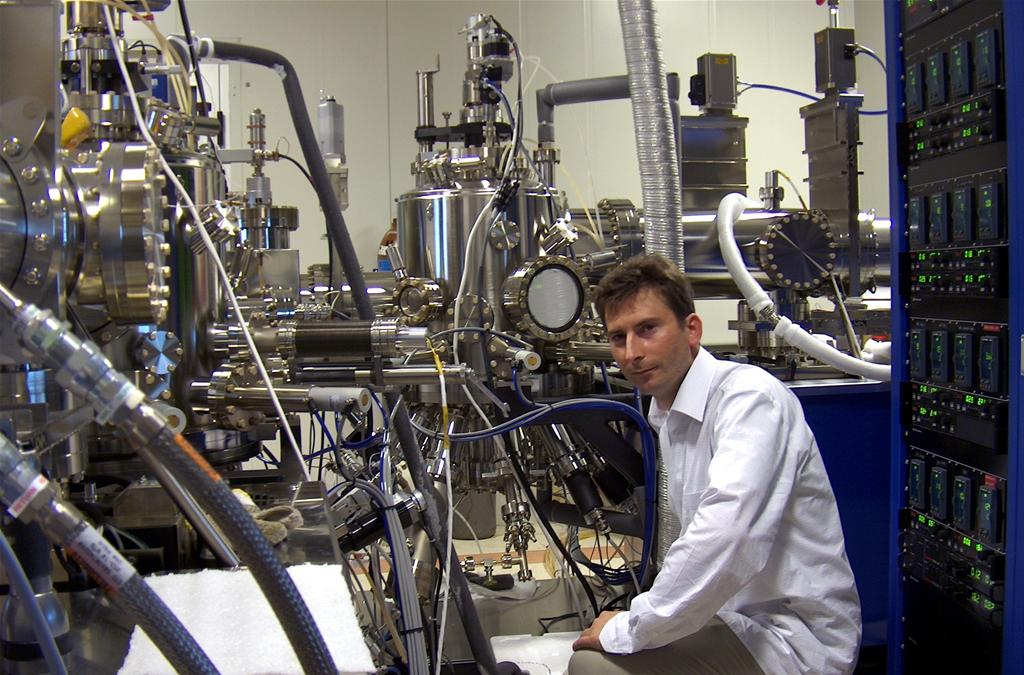 W Instytucie Fizyki Doświadczalnej Wydziału Fizyki Uniwersytetu Warszawskiego opracowano, skonstruowano i przetestowano nowatorskie kropki kwantowe z pojedynczymi jonami kobaltu. Na zdjęciu dr Wojciech Pacuski przy aparaturze do epitaksji z wiązek molekularnych użytej do budowy kropek kwantowych. Źr&oacute;dło: FUW