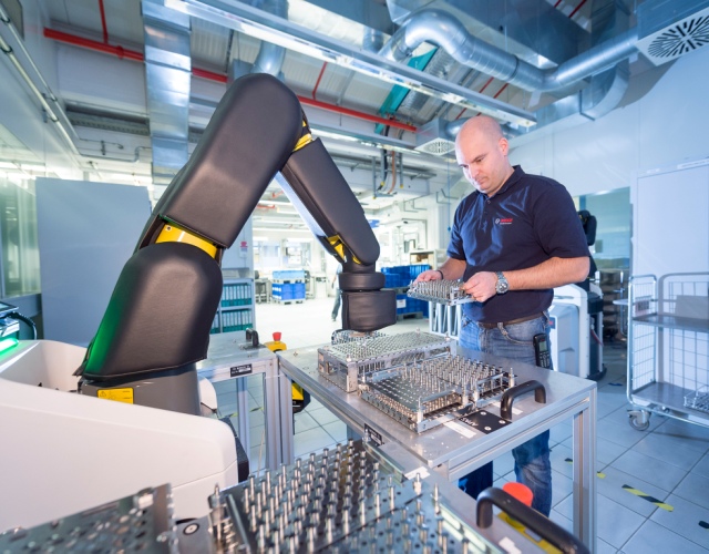 W fabryce Boscha w Stuttgart-Feuerbach, pracownik współpracuje z automatycznym asystentem produkcji lub APAS. Ramię robota jest wyposażone w czujnik skóry, który wykrywa obecność człowieka pracującego przy maszynie. Jeśli ktoś podejdzie zbyt blisko, asystent produkcji zatrzymuje się natychmiast, bez dotykania pracownika. Stowarzyszenie ubezpieczeń od odpowiedzialności pracodawców przyznało APAS certyfikat bezpieczeństwa do bezpośredniej współpracy z ludźmi.