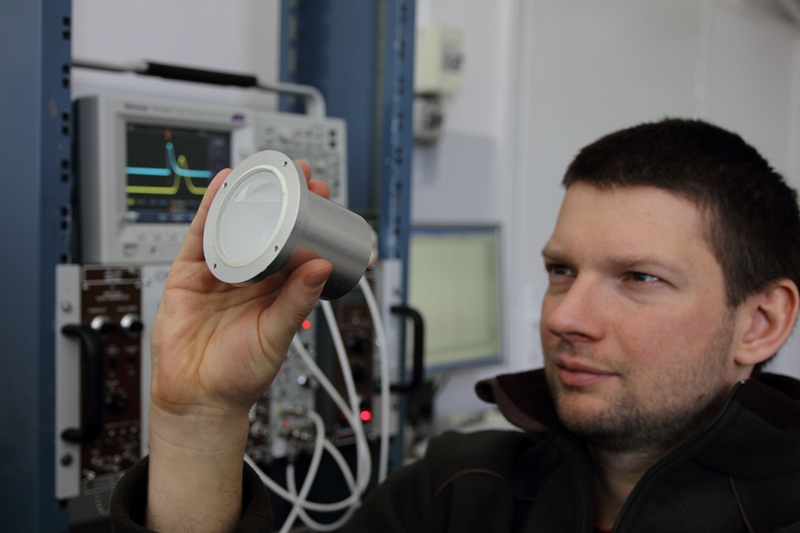 Dr Łukasz Świderski (IPJ) prezentuje próbkę ciekłego scyntylatora.