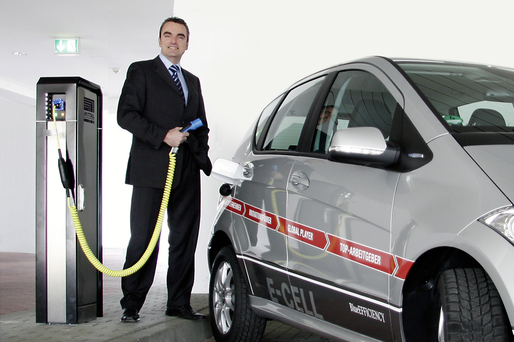 W drodze bez emisji spalin: dr Guido Stannek, Executive Vice President Supply Chain Management w Rittal, tankuje nowy samochód elektryczny prądem ze źródeł ekologicznych